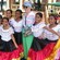 Un grupo de mujeres jóvenes posan y sonríen junto a una mujer mayor